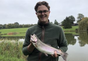 Happy angler displays his first trout caught fly fishing!